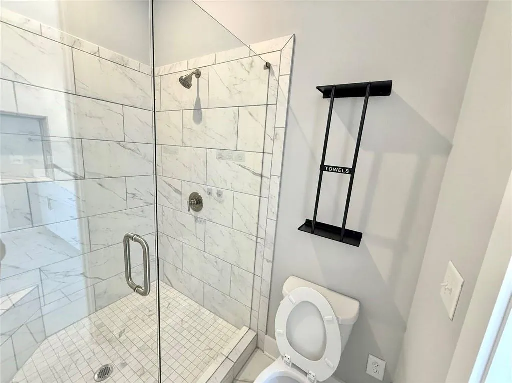 Bathroom featuring toilet and a stall shower