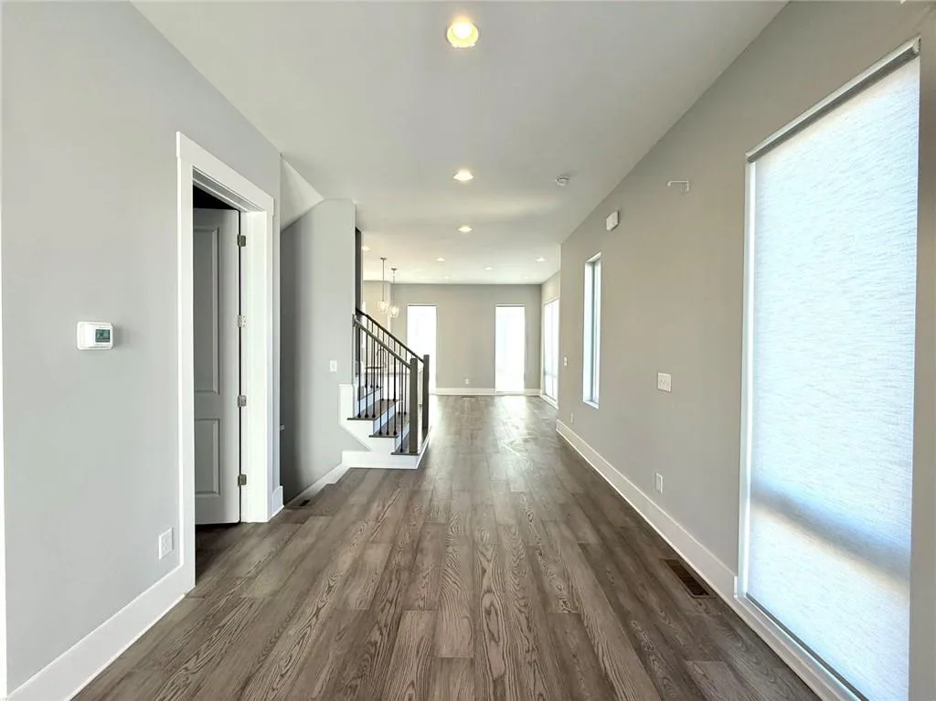 Hallway featuring recessed lighting, visible vents, baseboards, stairway, and dark wood-style floors
