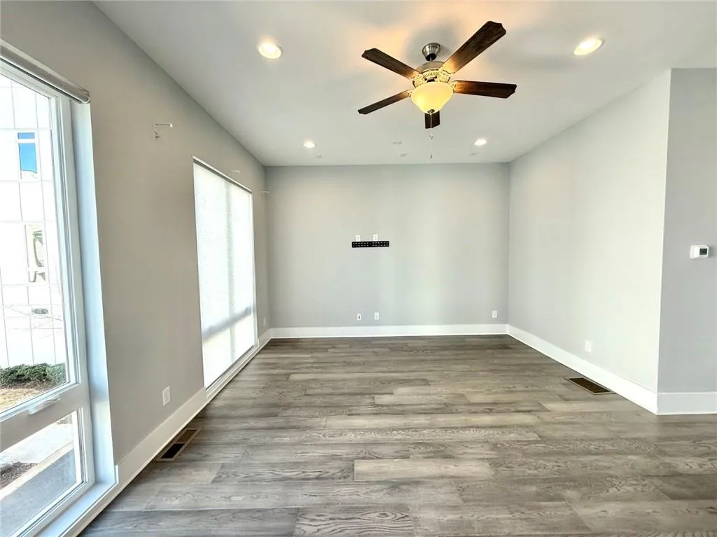 Empty room featuring baseboards, visible vents, wood finished floors, and recessed lighting