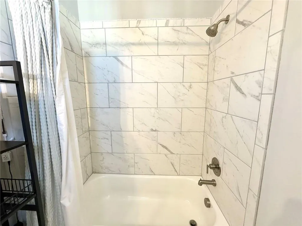 Full bath with shower / bath combination with curtain