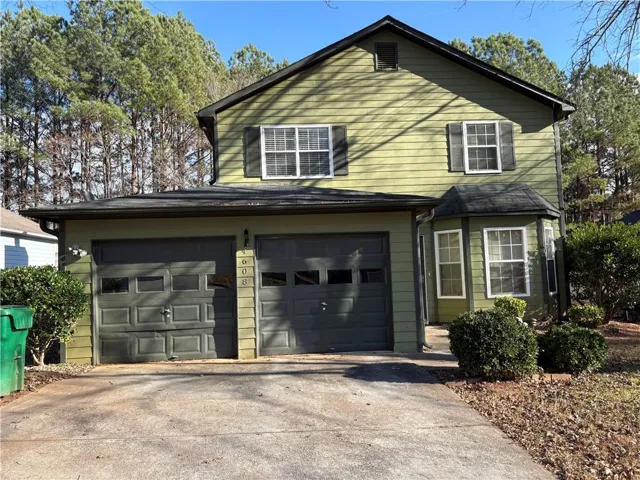 Two-story residence featuring light green siding and a dark roofline
