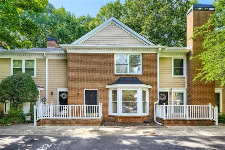 Brick and siding exterior featuring a prominent bay window with a dark awning