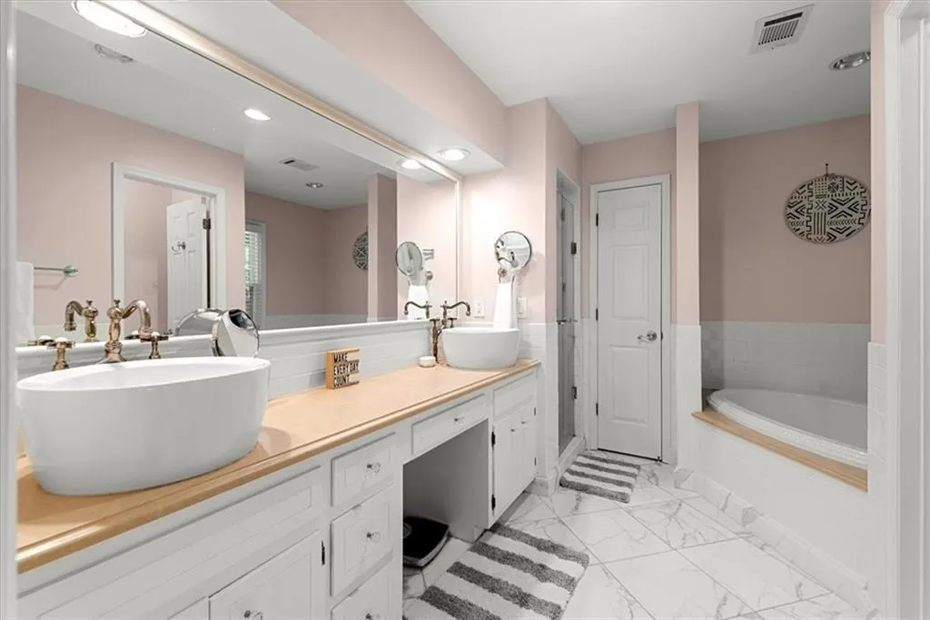 Bathroom with tile flooring, soaking tub, and dual vanity