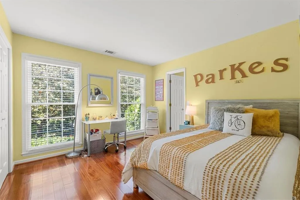 Bedroom with multiple windows and hardwood  flooring