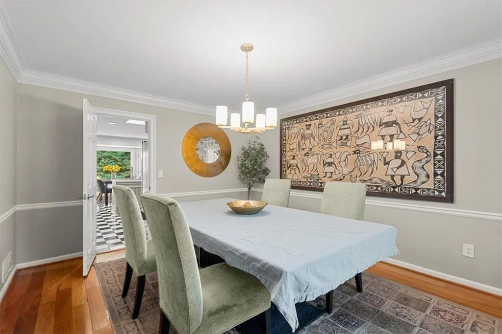Dining space featuring ornamental molding, a chandelier, and hardwood flooring