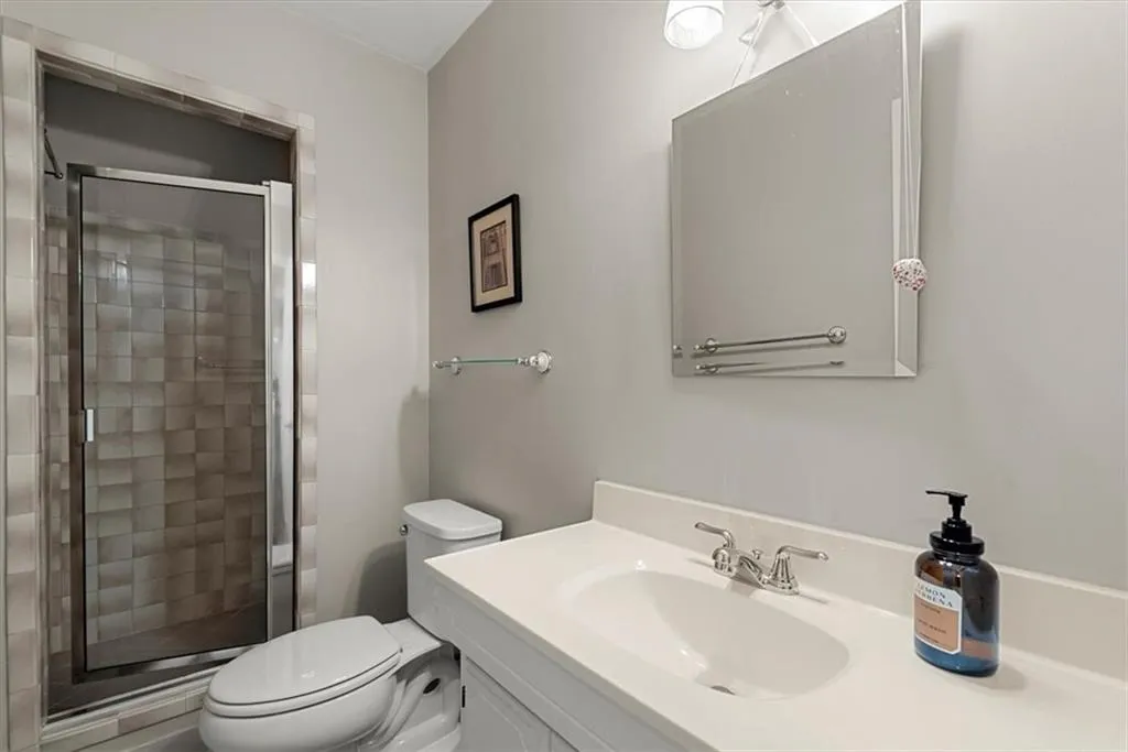 Upstairs Bathroom featuring an enclosed shower, toilet, and vanity