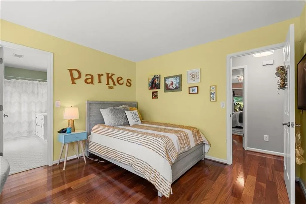 Bedroom featuring hardwood flooring and ensuite shared bath
