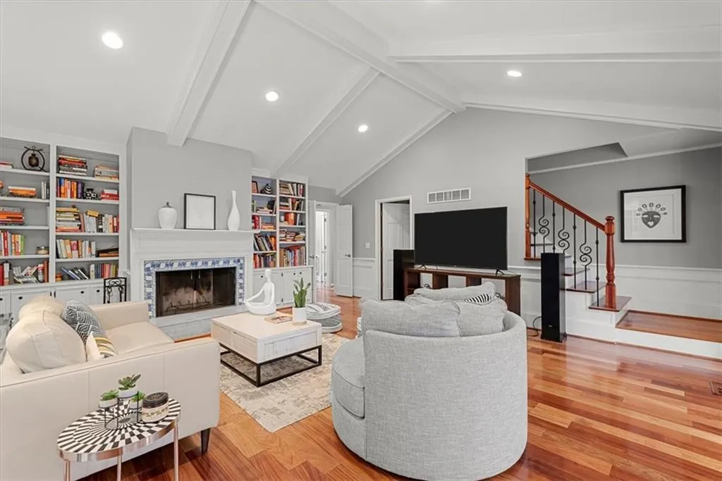 Family room featuring high vaulted ceiling, beamed ceiling, and hardwood floors