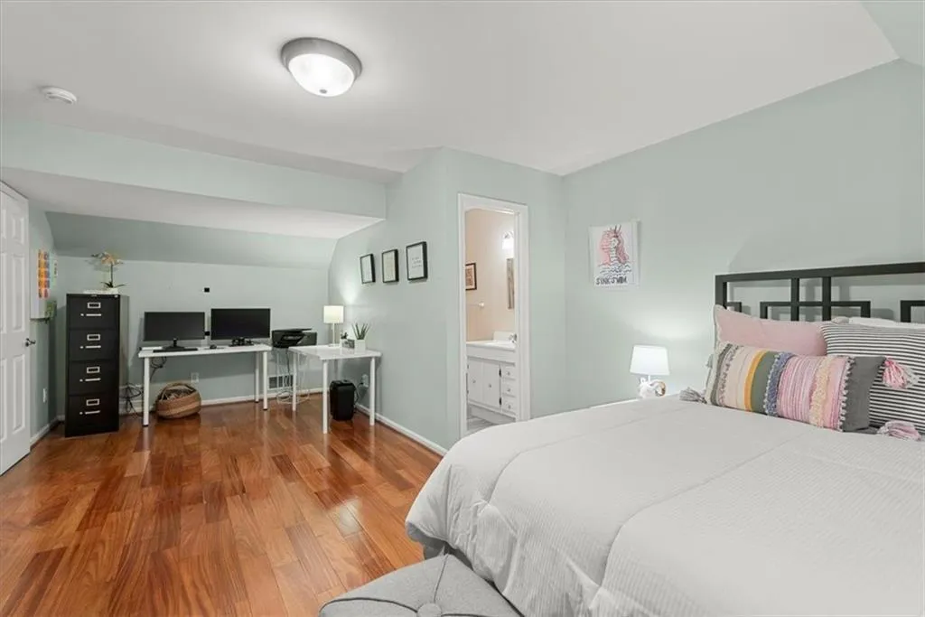 Upstairs Bedroom featuring hardwood floors, room for office, and ensuite bath