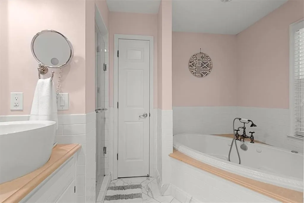 Bathroom with tile floors, soaking tub, and dual vanity