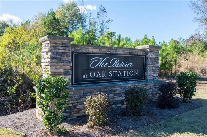 Stone veneer monument sign for "The Reserve at Oak Station" with natural landscaping