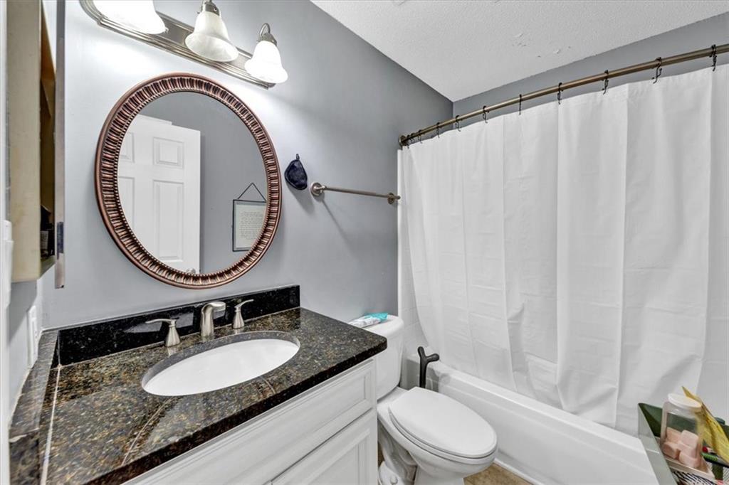 Renovated owner's suite bathroom featuring shower/bath combo.  New vanity/granite counters for cohesive look.