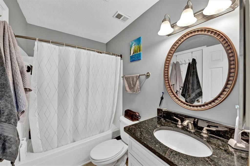 Full guest bathroom featuring shower/bath combo, vanity and granite counters!