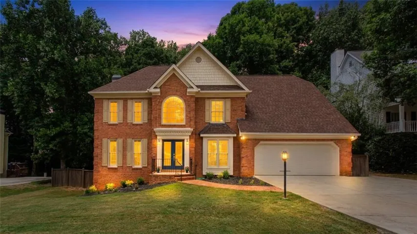 Brick exterior with a shingle roof and white gables