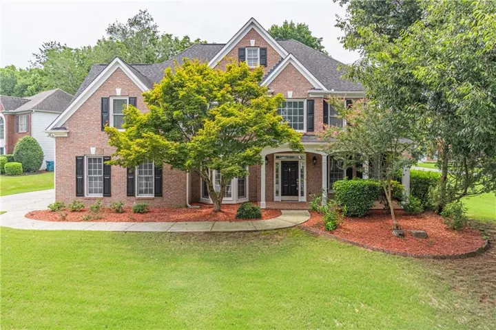 Brick exterior featuring white trim and black shutters