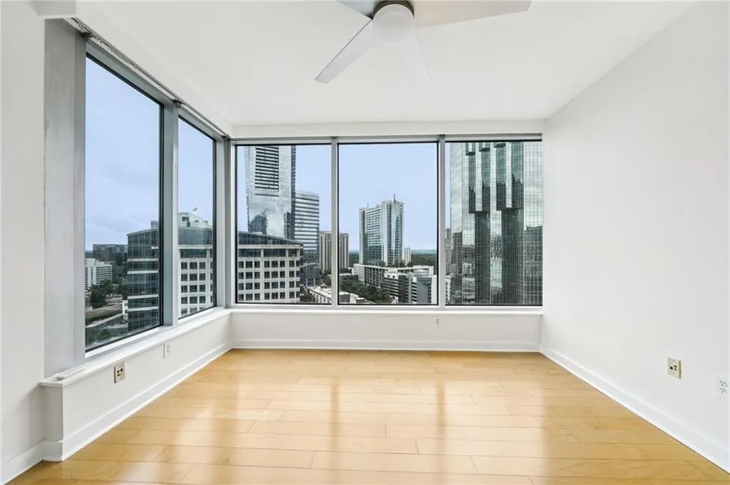 Spare room with a view of skyline, light wood-style flooring, and a ceiling fan