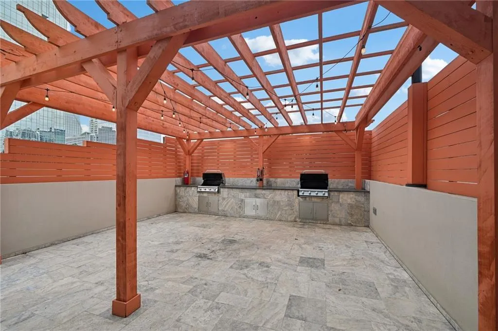 View of patio featuring exterior kitchen and a pergola