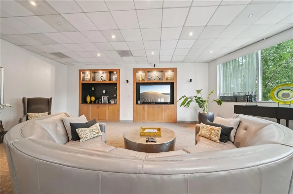 Living room with built in shelves, carpet floors, recessed lighting, and a drop ceiling