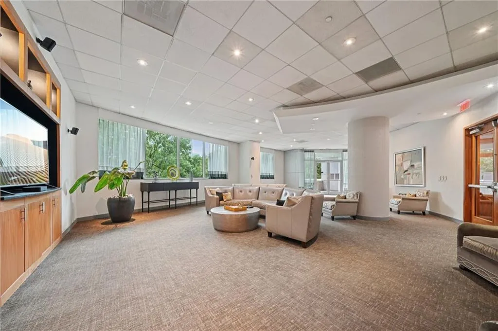 Carpeted living area with recessed lighting and a paneled ceiling