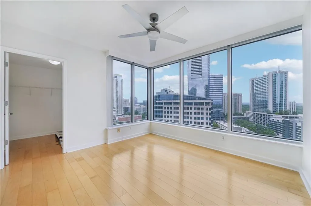 Spare room with a view of skyline, light wood-style floors, and ceiling fan