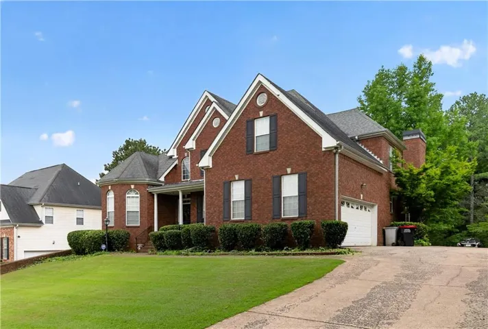Brick exterior featuring multiple gables, white trim, and dark shutters