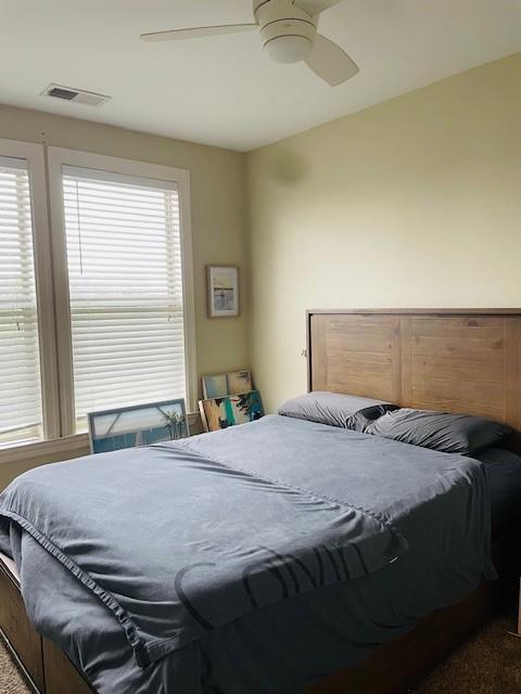 Bedroom featuring dark colored carpet and ceiling fan