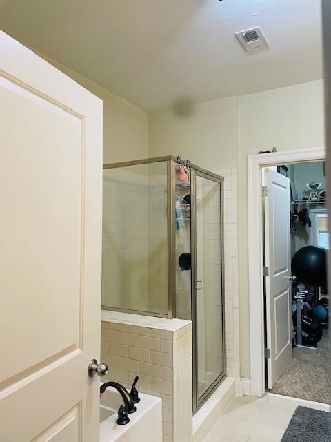 Bathroom with a shower with shower door and tile flooring