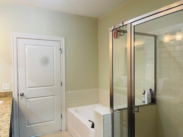 Bathroom featuring vanity, tile floors, and plus walk in shower