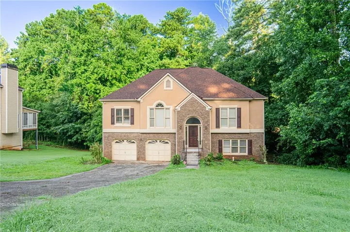 Two-story brick Colonial with a steeply pitched roof, arched entry portico, and symmetrical facade