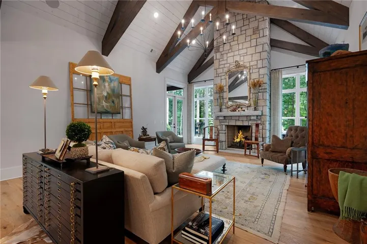 Spectacular vaulted ceiling with soaring fireplace, exposed wood beams and white plank finishing