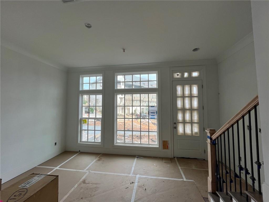 Doorway to outside featuring crown molding and 10 foot ceilings on main level!