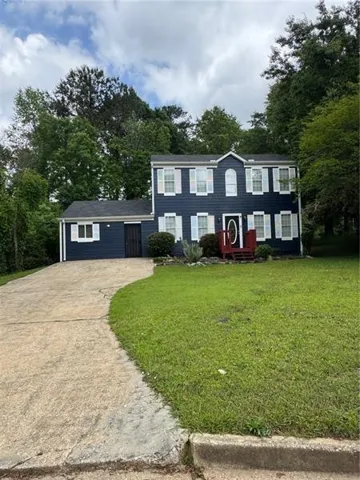 Two-story residence featuring navy blue siding with white window shutters