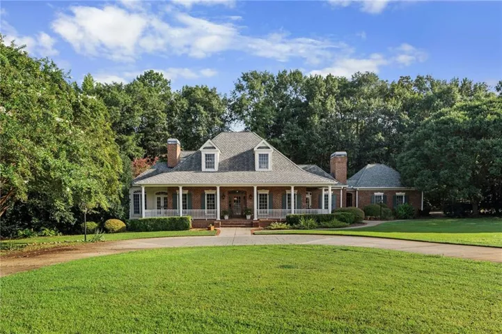 Brick exterior with white columns and dormer windows