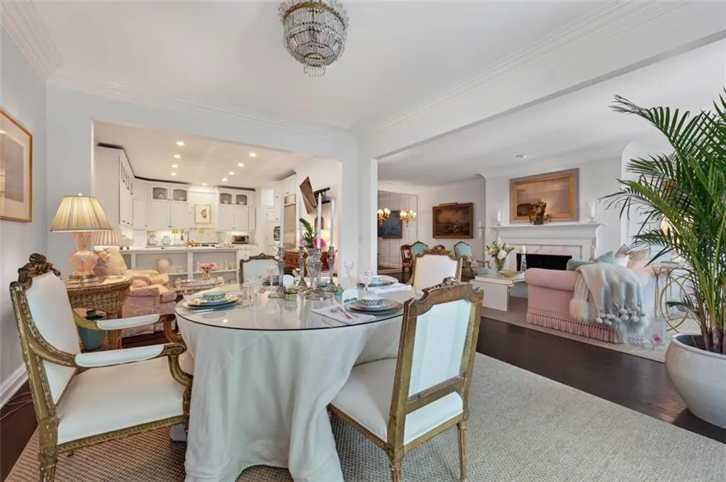 Recessed lighting, crown molding, white painted cabinetry, and a fireplace with a mantel