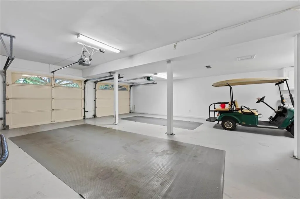 Spacious garage featuring two overhead doors, an automatic door opener, and durable flooring with integrated mats