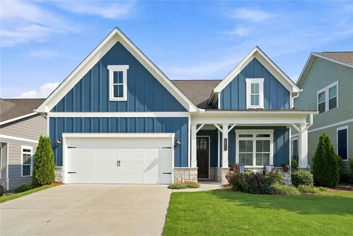 Craftsman-style exterior featuring blue board and batten siding with white trim