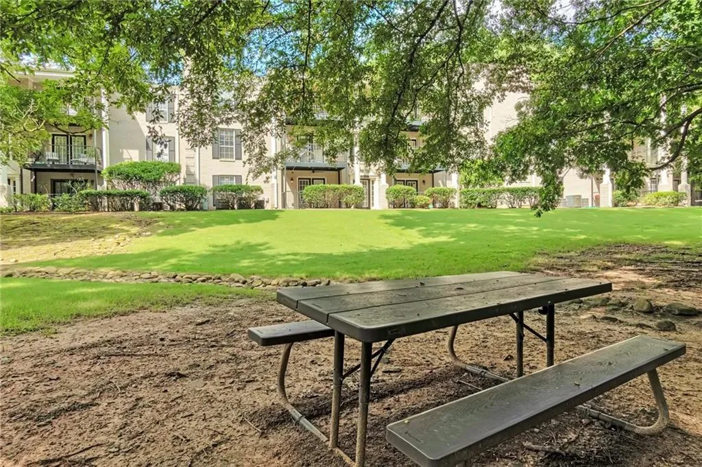 Expansive lawn behind building featuring picnic table.