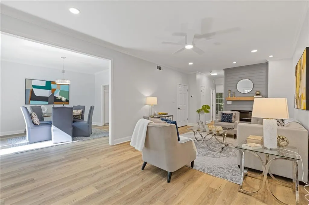 Living area featuring recessed lighting, light wood-style floors, crown molding, ceiling fan, and a chandelier