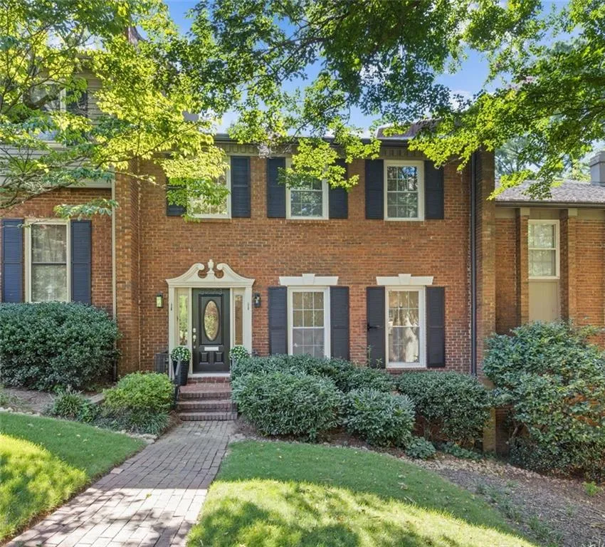 Colonial home featuring brick siding and a front yard