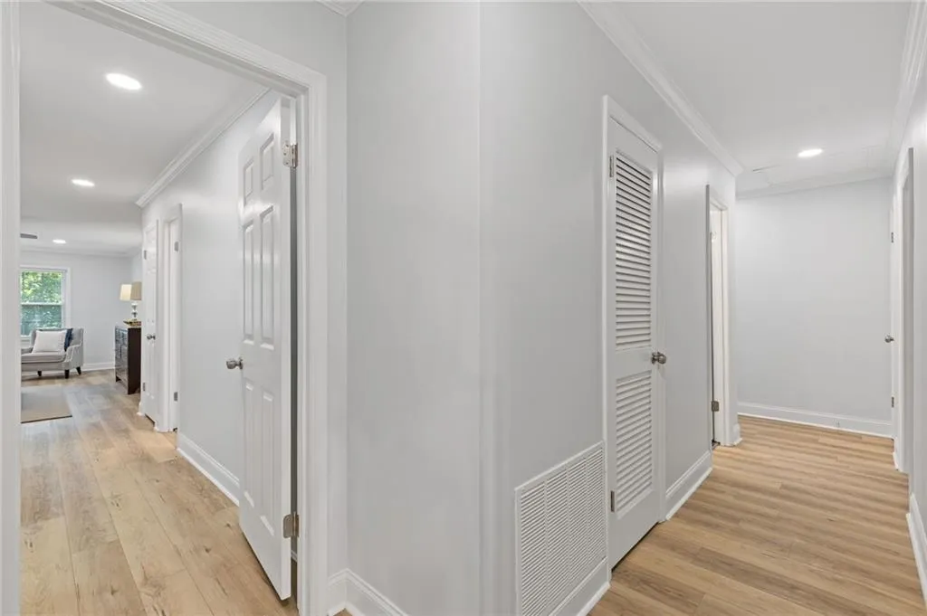 Corridor with recessed lighting, ornamental molding, and light wood-type flooring