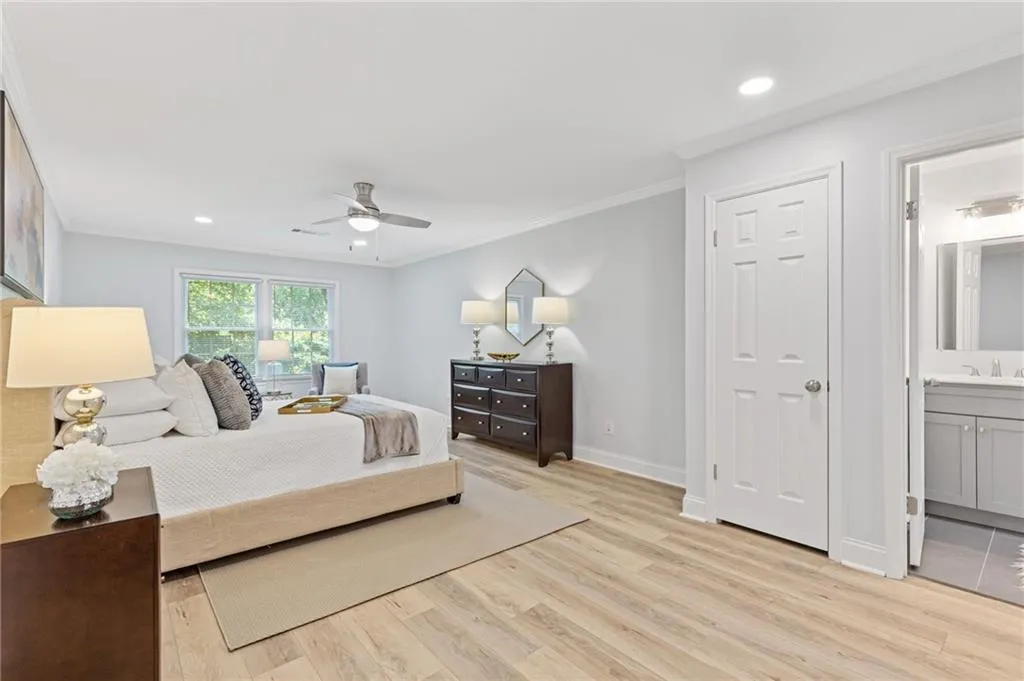 Bedroom featuring recessed lighting, ornamental molding, light wood-style floors, ensuite bathroom, and a ceiling fan