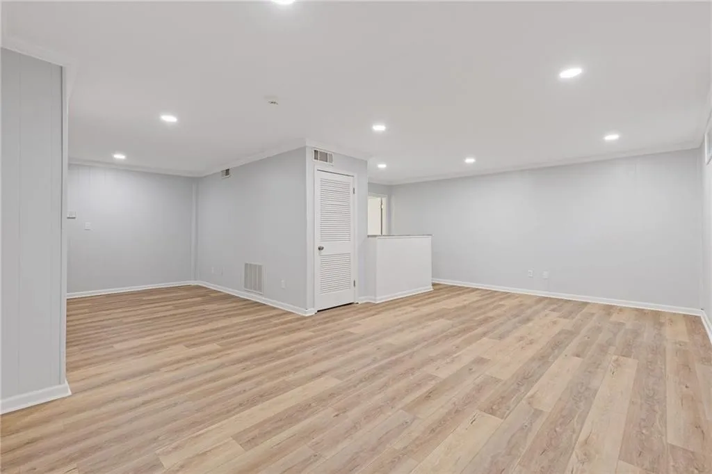 Unfurnished room featuring light wood-type flooring, crown molding, and recessed lighting
