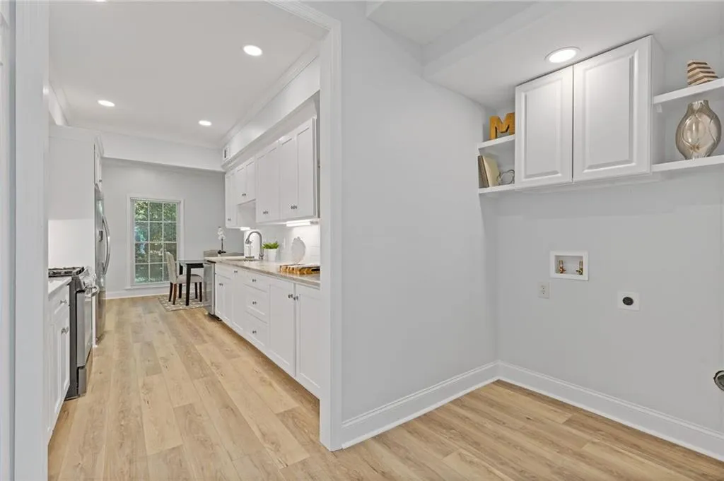 Washroom with electric dryer hookup, light wood-style flooring, hookup for a washing machine, recessed lighting, and cabinet space