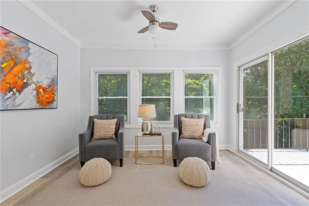 Sunroom area featuring wood finished floors, a ceiling fan, and ornamental molding