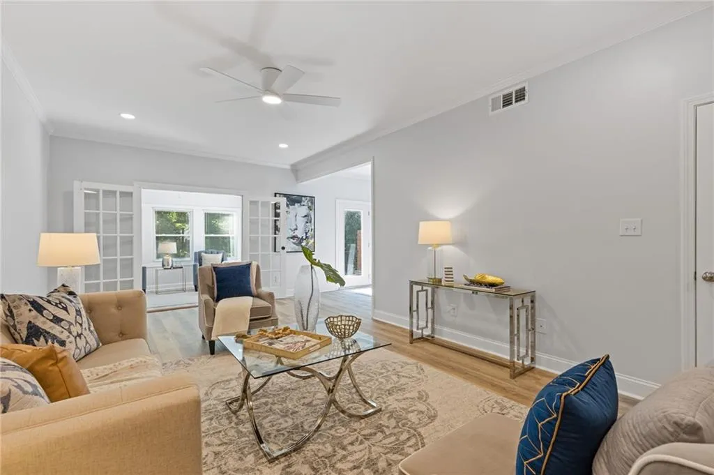 Living area with crown molding, wood finished floors, a ceiling fan, and recessed lighting
