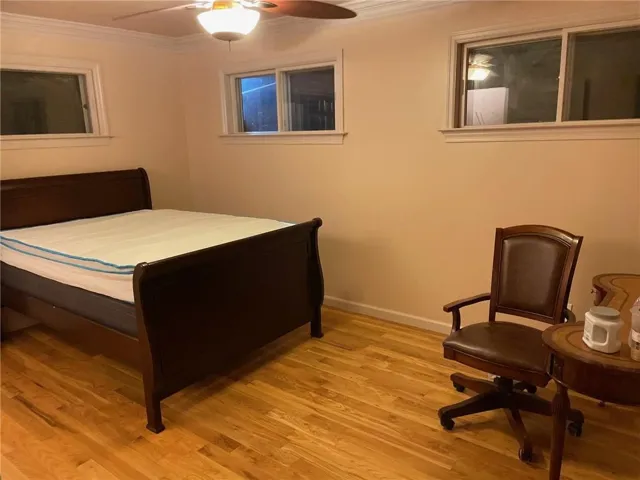Bedroom featuring ornamental molding, light wood-type flooring, and ceiling fan