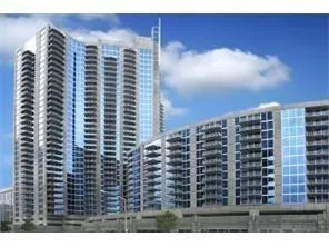 Modern high-rise architecture with a curved facade, expansive glass windows, and private balconies