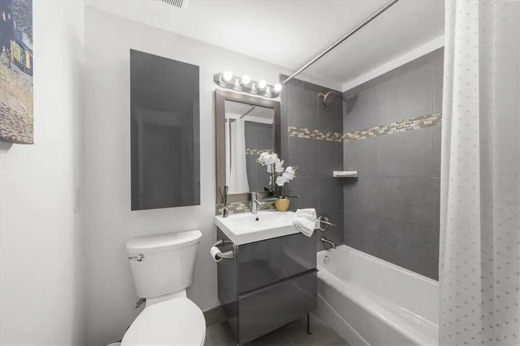 Full bath featuring shower / tub combination, vanity, and tile patterned flooring