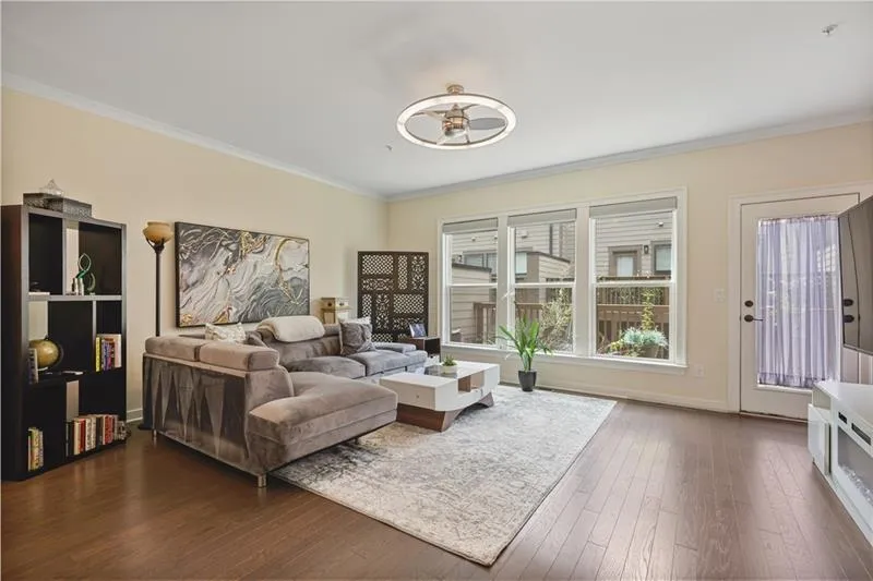 Living room with ornamental molding and dark wood finished floors