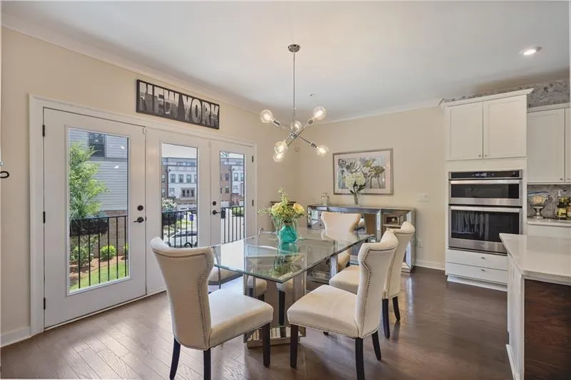 Dining area featuring ornamental molding, dark wood finished floors, a chandelier, and french doors